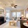 Spacious and well lit living room with wood flooring, large windows and open access to the kitchen